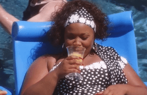 gif of micky from baps relaxing in the pool and smiling with her silver teeth shining